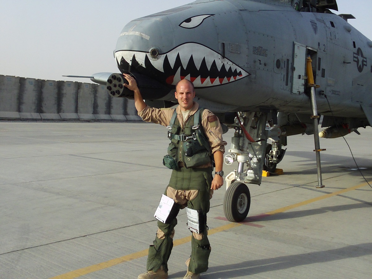 Caucasian male in uniform in front of plane