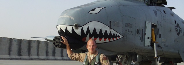 Caucasian male in uniform in front of plane