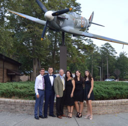 group of pepole photographed in front of former fighter aircraft