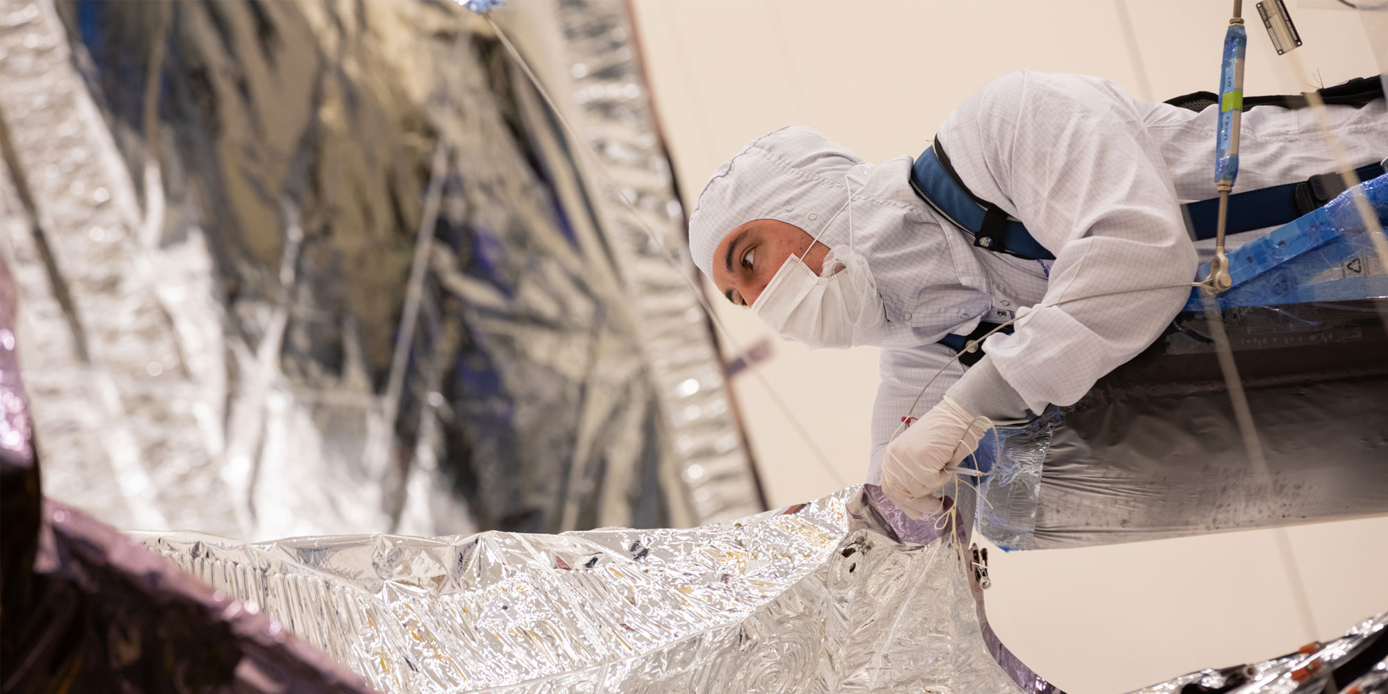 A Northrop Grumman employee inspects the James Webb Space Telescope Sunshield.