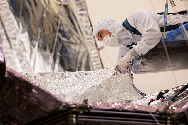 A Northrop Grumman employee inspects the James Webb Space Telescope Sunshield
