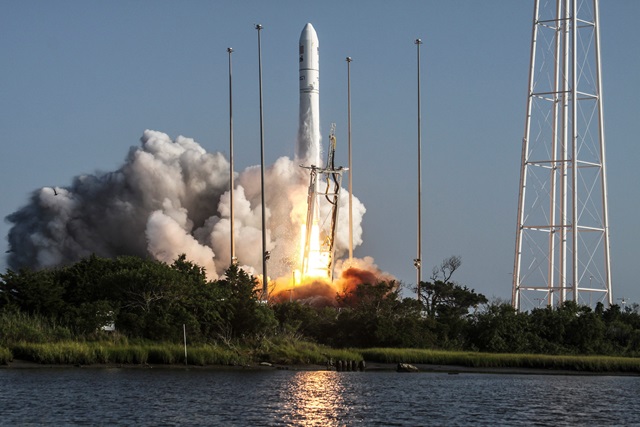 The Antares rocket launches behind a lakeview