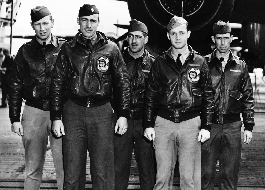 Five pilots standing in front of a plane for a group picture