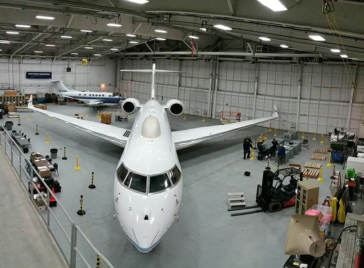 Interior of hanger with white jet looking head-on
