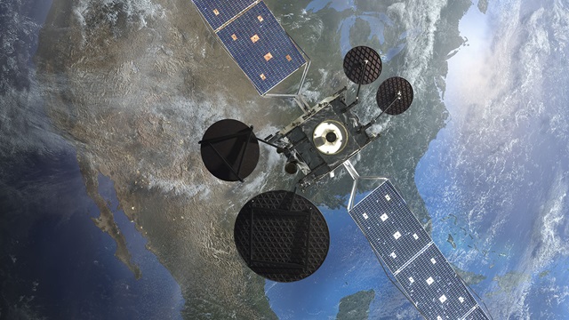 Large satellites hovers over the continent of North America in outerspace