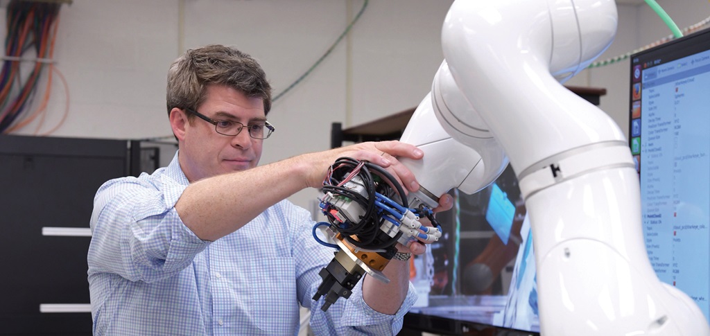 A man holds a robotic arm