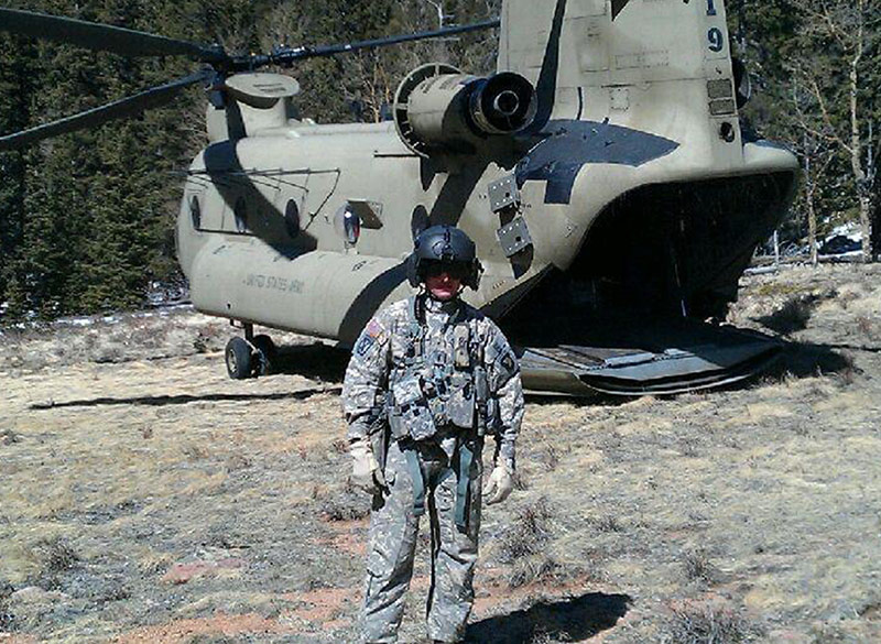 military pilot standing in front of helicopter
