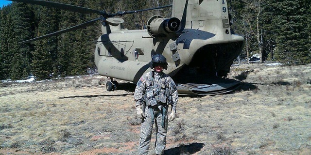 military pilot standing in front of helicopter