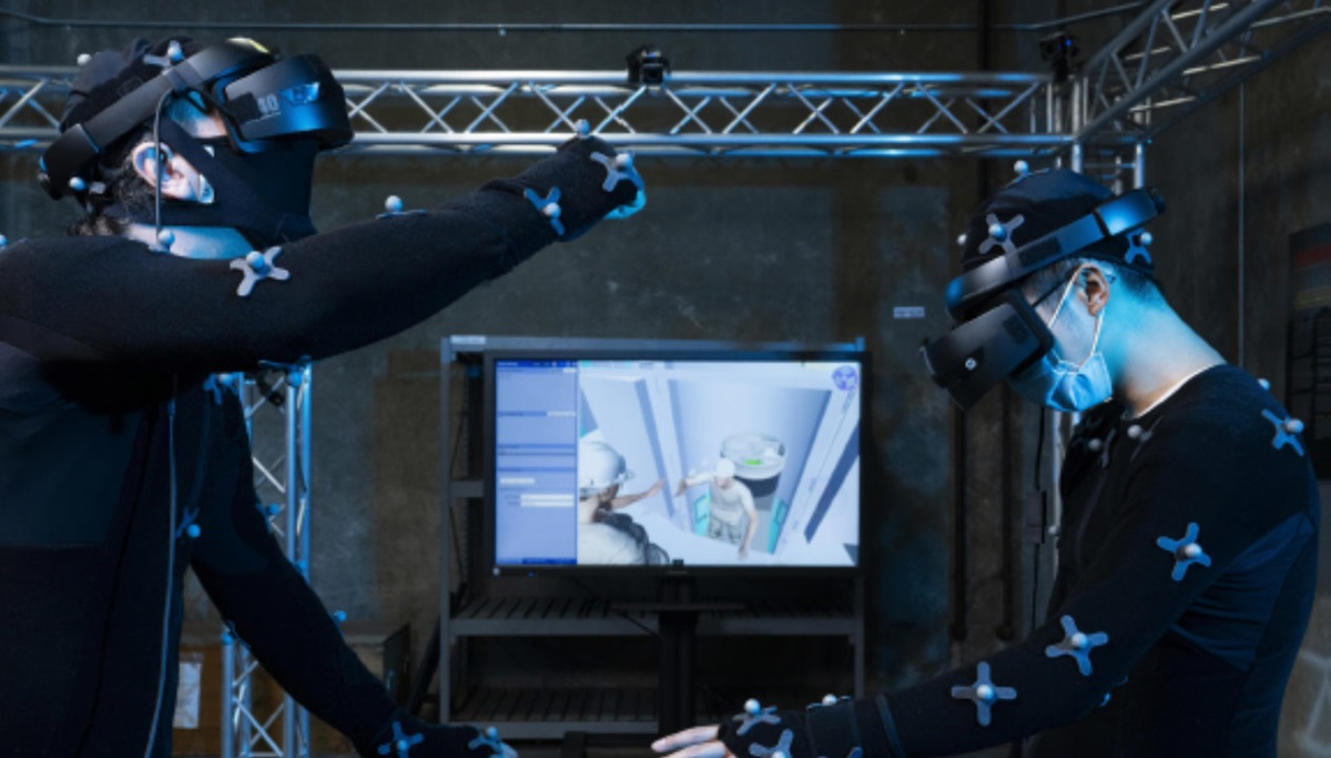 Two individuals participating in a Highly Immersive Virtual Environment