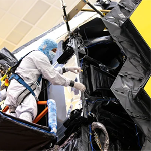 Engineer in clean suit working on the James Webb Space Telescope