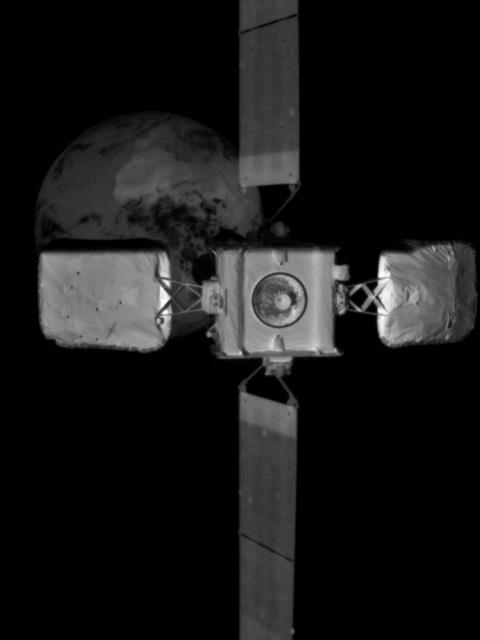 A black and white space image of an Intelsat satellite with Earth in background