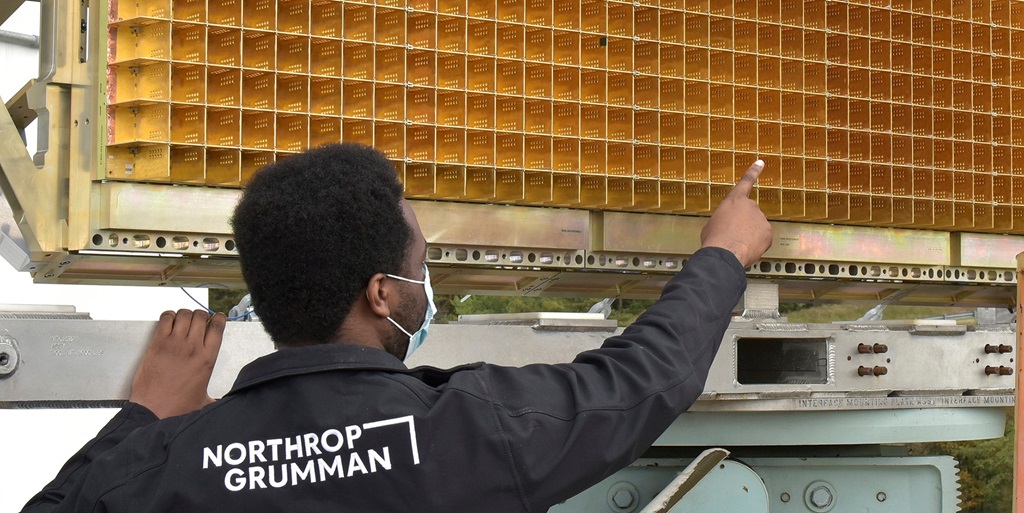 A man wearing a Northrop Grumman jacket points to a sensor panel