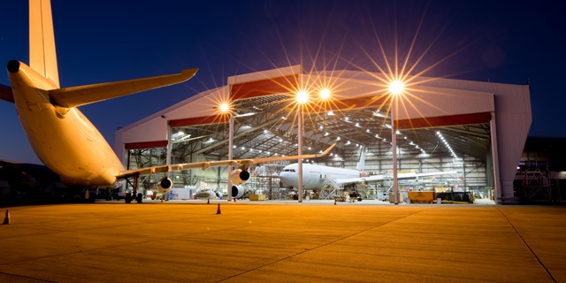 large aircraft in front of large hangar