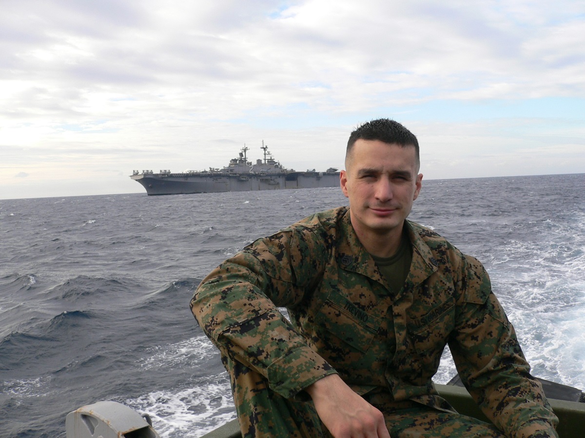 Man in military uniform with ship in background