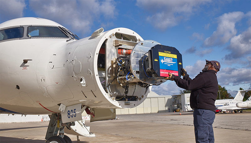 man installing radar in plane nose