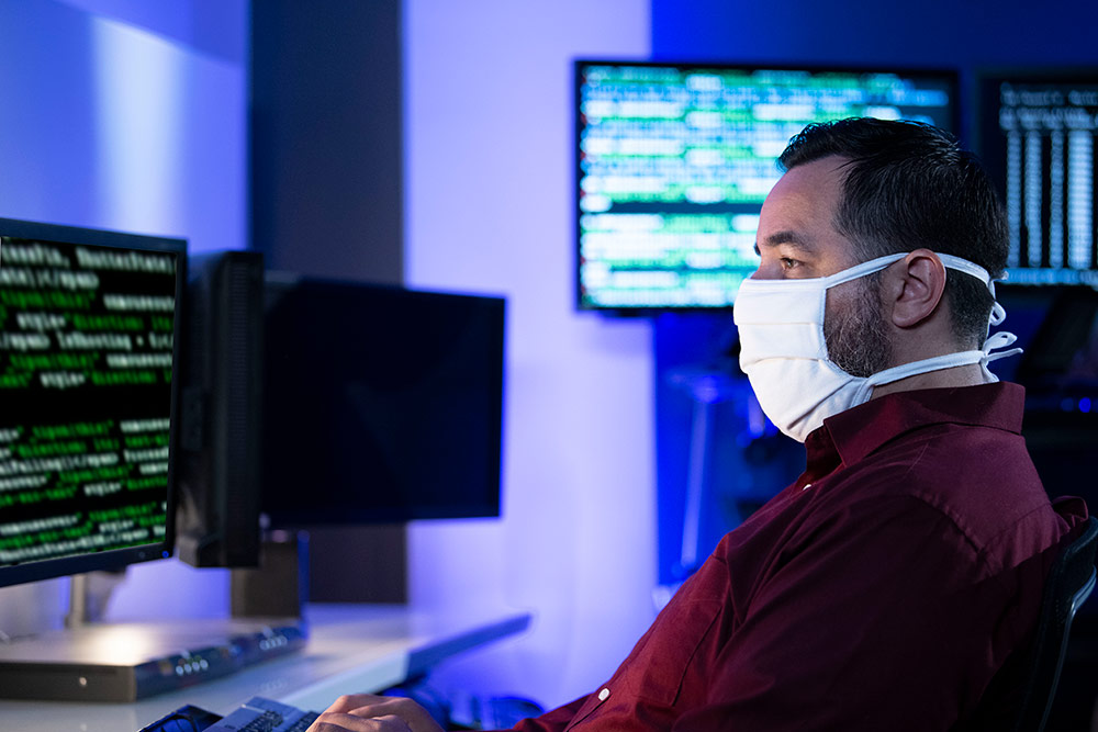 man on computer wearing mask