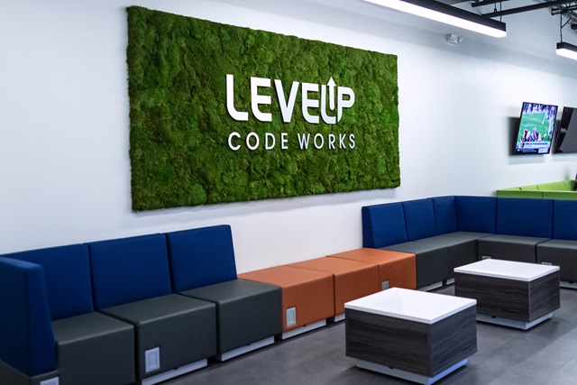 Office setting with couches and a green sign on the wall saying LEVEL Up