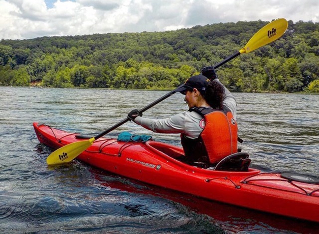 woman paddling kayak in river