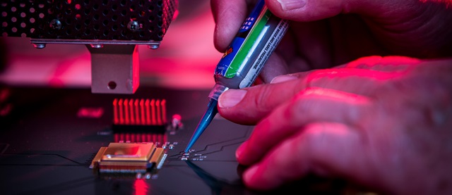 hand attaching microchip to motherboard