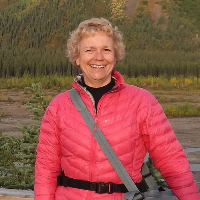 white woman in jacket in mountains
