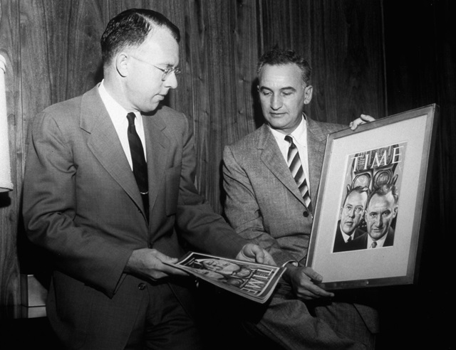 black and white photo with two men holding picture frame