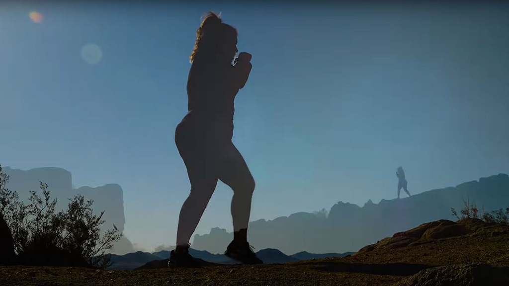 woman shadow boxing on mountain trail