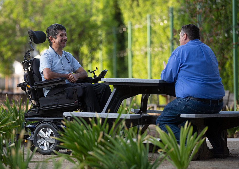 man in wheelchair at picnic table